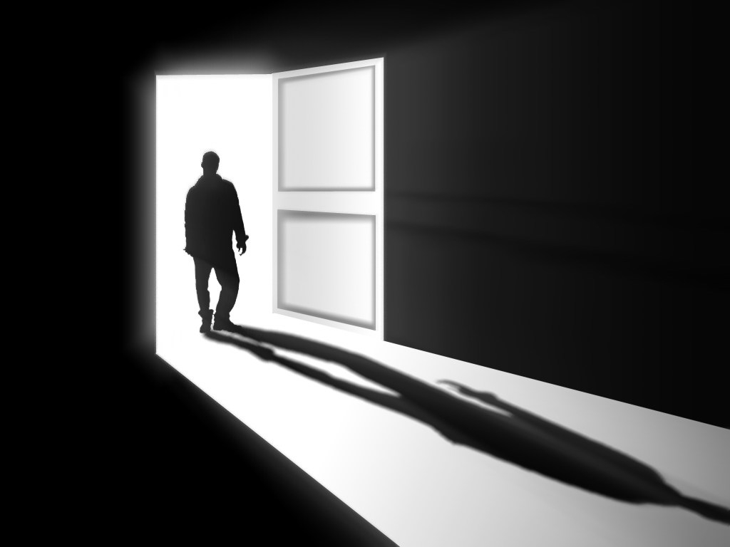 Black and white figure standing in doorway.