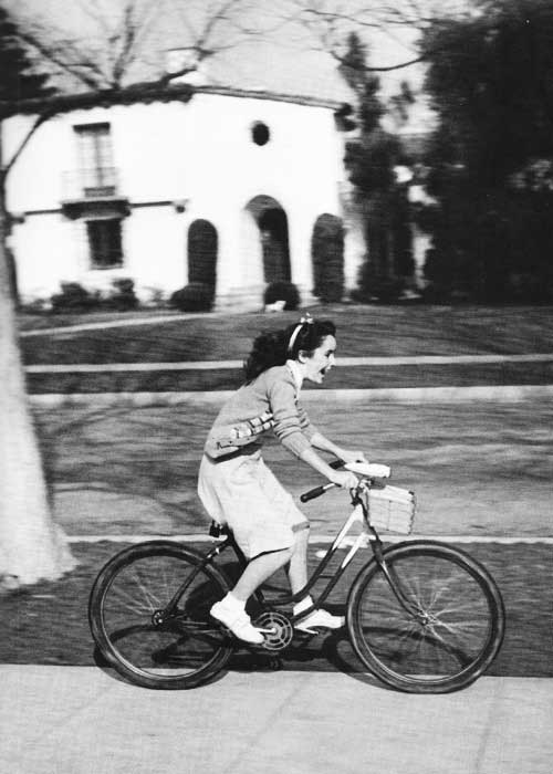 A 12 year old Elizabeth Taylor riding her bike through Beverly Hills, 1944.